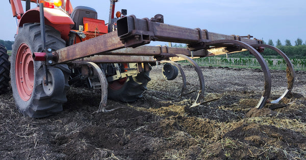 Tractor with a chisel plow in a field during daytime